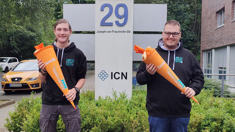 Begrüßung 2 neuer Azubis mit Schultüte in der Hand